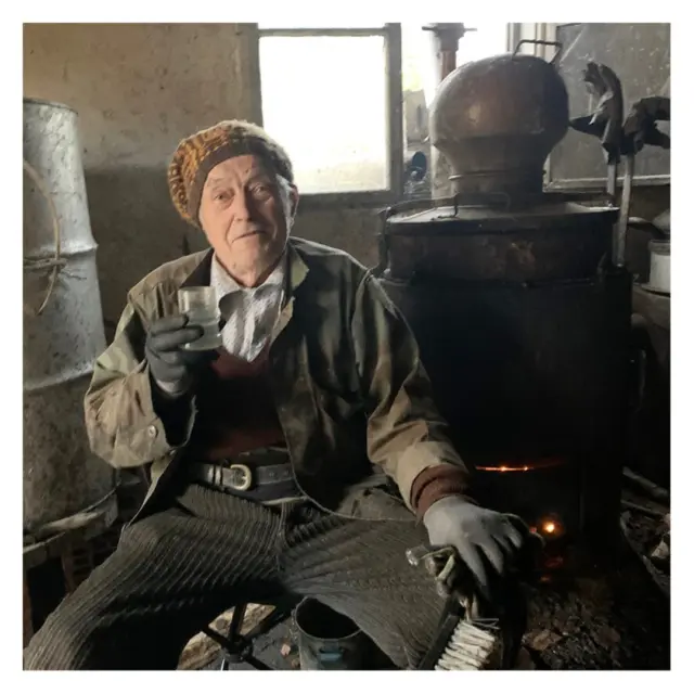 Village life - keeping warm with firewater brewing and a Pashin' hat. Which one kicks in faster is debatable... :D . . .